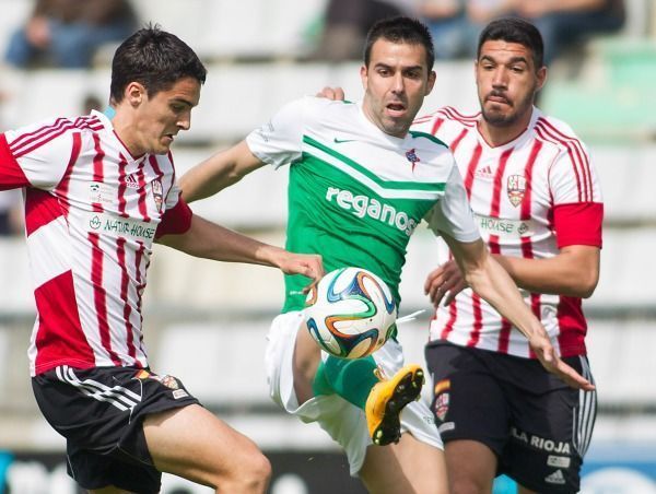 Entre dos rivales conduce Joselu el balón en el Racing-Logroñés (foto: Mero Barral / 13fotos)