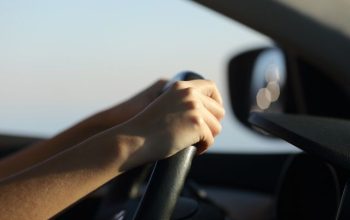 Driver hands holding steering wheel driving a car