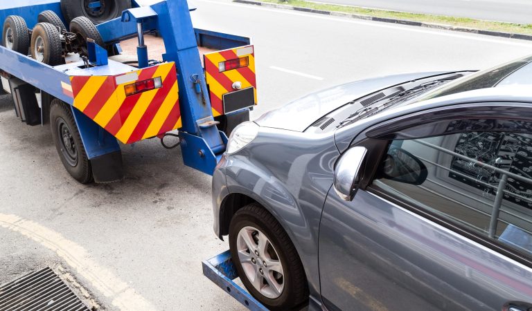 tow-truck-towing-a-broken-down-car-on-the-street